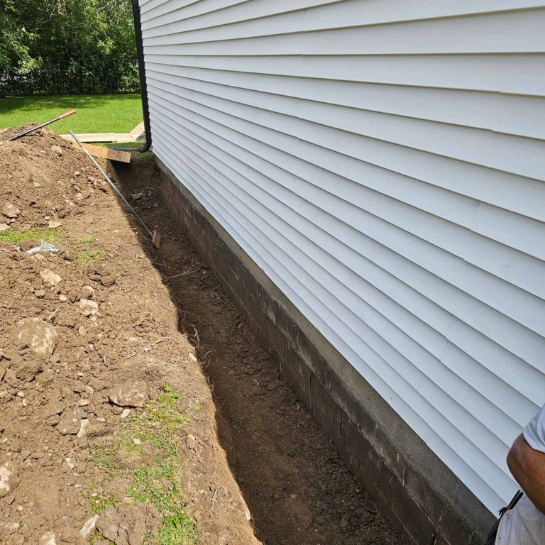 Trench dug along home foundation to begin foundation repairs